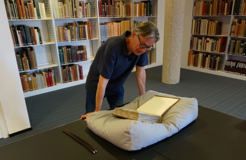 De auteur bij de oude Leidse codex, de Codex Sarravianus in de Universiteitsbibliotheek (Archief TB)