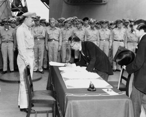 De Japanse buitenlandminister Mamoru Shigemitsu ondertekent het overgave-document aan boord van de USS Missouri, terwijl generaal Richard K. Sutherland toekijkt, 2 september 1945