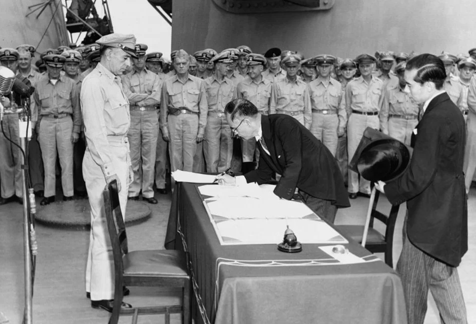 De Japanse buitenlandminister Mamoru Shigemitsu ondertekent het overgave-document aan boord van de USS Missouri, terwijl generaal Richard K. Sutherland toekijkt, 2 september 1945