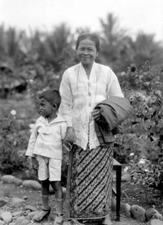 Portret van een vrouw in sarong en kabaja met kind aan de hand.  (CC BY-SA 3.0 – Tropenmuseum – wiki)