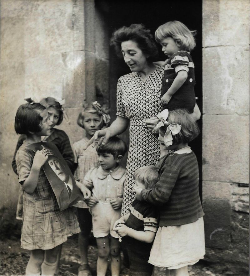 Een moeder met kinderen die het portret van Pétain vasthouden, ca. 1940-1944