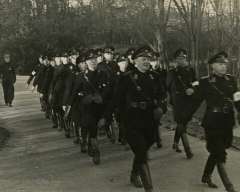WA'ers marcheren door een park, 1941. Links een bord 'Verboden voor joden' (Fotodienst der NSB)