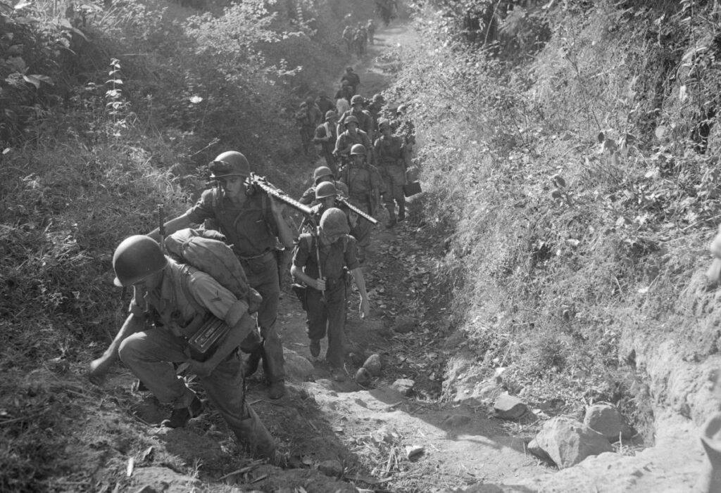 Een mitrailleursectie van de mariniers rukt op in bergachtig terrein in Oost-Java, vermoedelijk eind 1947.