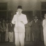 Soekarno leest de Indonesische onafhankelijkheidsverklaring voor. Rechts in witte kleding Hatta. Het is 17 augustus 1945 en heel veel is nog onzeker.