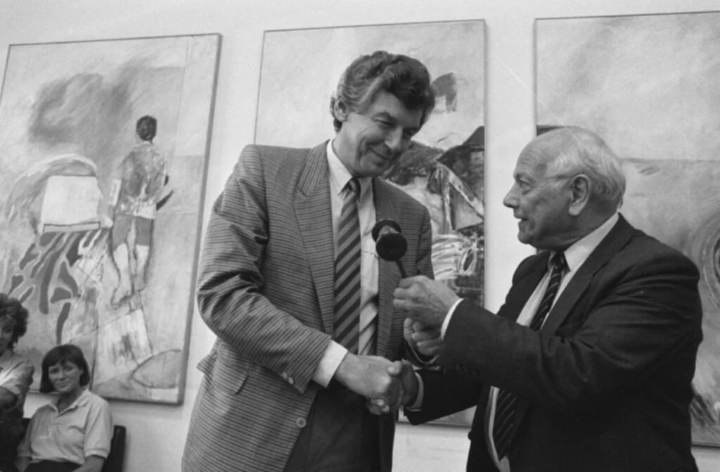 Joop den Uyl overhandigt voorzittershamer aan Wim Kok, 21 juli 1986 (CC0 - Anefo - Rob Croes - wiki)