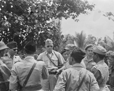Nederlandse en Indonesische officieren overleggen in januari 1948 op Sumatra met internationale militaire waarnemers. In het midden met zonnebril de Amerikaanse kapitein J.A. Mac Naill, links naast hem, ook met zonnebril de Franse kapitein J. Rousset.
