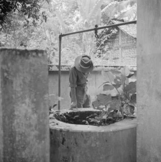 Een KNIL-militair kijkt in Depok (West-Java) in een put waarin de lichamen van een man en een vrouw zijn gegooid. In Depok woonden veel christelijke Indonesiërs. Pemuda vermoordden er 33 mensen op 11 april 1946. (Nationaal Archief/W. van de Poll) 