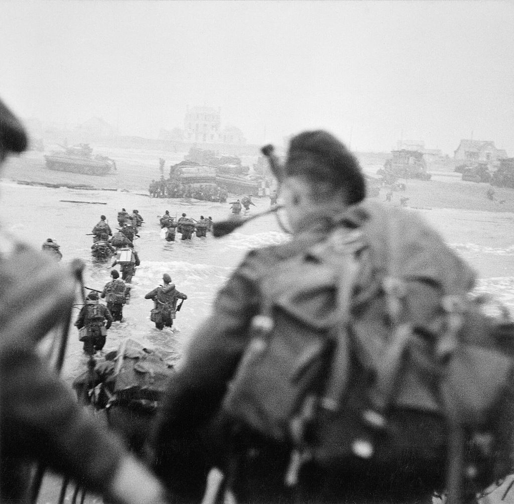 Landing op Sword Beach. Lord Lavat loopt in het water, rechts van zijn mannen. Bill Millin is op de  voorgrond te zien en staat op het punt van boord te gaan, 6 juni 1944