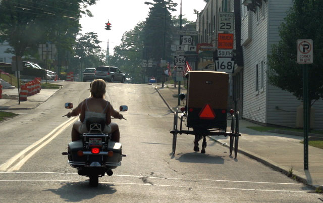 In één beeld gevangen. Rechts een paard en wagen van een lid van de Amish-gemeenschap. Links een moderne motorrijder.