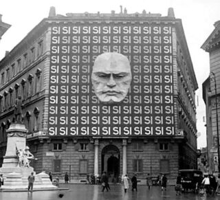 Gevel van het Palazzo Braschi, Rome, in 1934, met Mussolini's gezicht en het woord "SI" (ja) herhaald. Campagne voor het referendum van maart 1934
