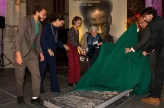 Onthulling gedenksteen door (v.l.n.r.) Raoul de Jong, Burgemeester Femke Halsema, Geertje van Houten, Judith de Kom, Ambassadeur Rajendre Khargi en Vincent de Kom