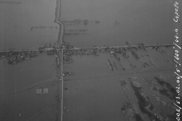Luchtfoto van de woningen aan de Waspiksedijk tussen Capelle (rechts) en Waspik (links) en een overzicht van het door de ramp getroffen gebied