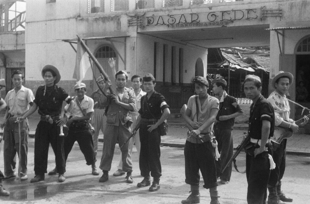 Indonesische strijders op 12 november 1949 voor de uitgebrande Pasar Gede ofwel Grote Markt(hal) in Solo, Midden-Java.