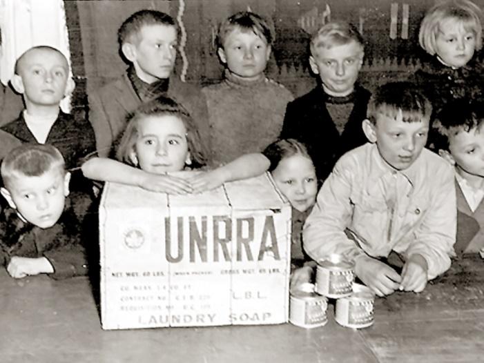 (Vermoedelijk) Poolse kinderen met een UNRRA-hulppakket uit Canada.