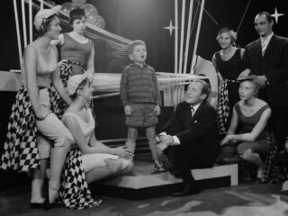 Het allereerste tv-optreden van André vond plaats in de AVRO Weekend Show, op 3 oktober 1959. De achtjarige André zingt het lied Droomschip, op voorspraak van komiek/entertainer Johnny Kraaijkamp (zittend rechts). (Foto Anefo, Henk Lindeboom)