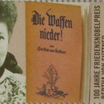 Oude uitgave van 'Die Waffen nieder!' en een foto van Bertha von Suttner op een Duitse postzegel uit 2005