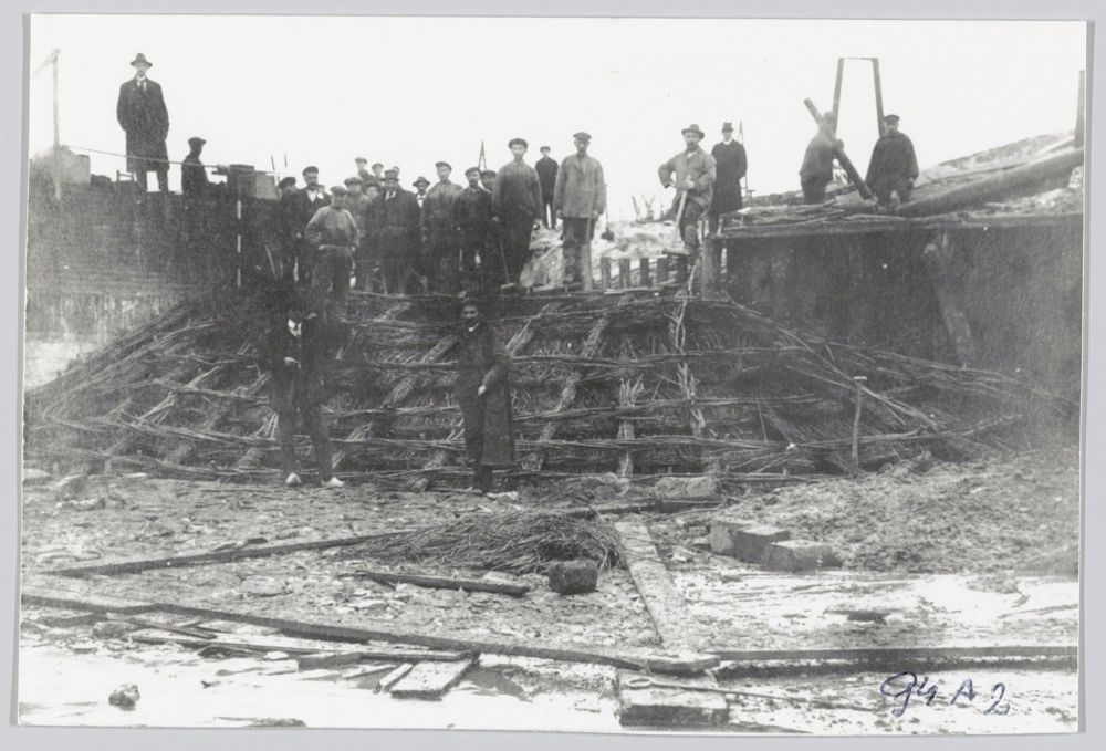 Grote groep mannen bij een zinkstuk voor onderhoud aan een strekdam - Historische Vereniging Callantsoog