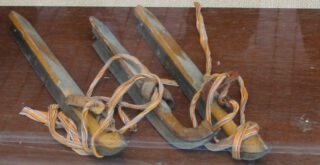 Oude houten schaatsen die onder de schoen gebonden worden met linten