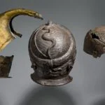 Drie Romeinse helmen - Messing (links) en ijzer (midden en rechts), hoogte messing helm links 38 cm., 50-300 na Chr., uit Vechten