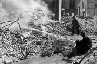 Nabluswerkzaamheden in de Wijnstraat ter hoogte van het pand van de Bank voor Handel en Scheepvaart. Eind mei 1940.