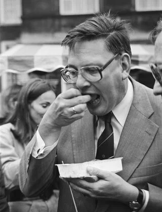 Politicus Gijs van Aardenne 'hapt toe' tijdens de jaarlijkse barbecue op het Binnenhof in Den Haag, 1981