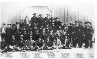 De Wyoming Invaders, kort na hun bevrijding door de cavalerie, poserend voor de poort van Fort D.A. Russell.