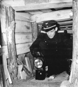 Ook na de bouw van de Berlijnse Muur probeerden inwoners van de DDR te ontvluchten. Hier is een Oost-Duitse agent te zien in  een ontdekte vluchttunnel, 1962