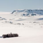 Het Hardangervidda is een bergplateau in Noorwegen met toppen tot 1.900 meter hoogte. Door de noordelijke ligging en de omliggende bergen is er ’s winters geen zonlicht te zien. Een groot deel van het jaar ligt er sneeuw. De hut op deze foto is niet dezelfde als in dit verhaal.