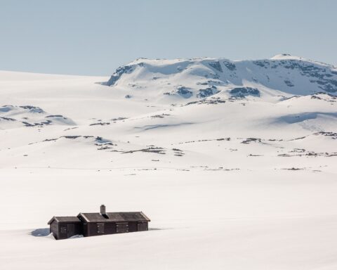 Het Hardangervidda is een bergplateau in Noorwegen met toppen tot 1.900 meter hoogte. Door de noordelijke ligging en de omliggende bergen is er ’s winters geen zonlicht te zien. Een groot deel van het jaar ligt er sneeuw. De hut op deze foto is niet dezelfde als in dit verhaal.