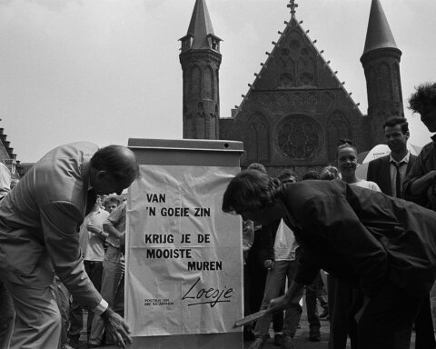 De Kamerleden Lankhorst (r) en Dijkstal plakken een Loesje-affiche op het Binnenhof, 30 juni 1988