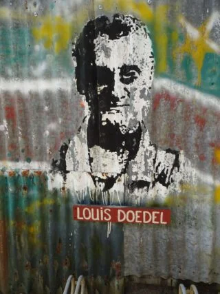Op een herdenkingsmuur in Paramaribo een portret van Louis Doedel.