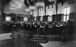 Deelnemers aan de conferentie zitten in vergadering in de Ridderzaal tijdens de Tweede Haagse Vredesconferentie