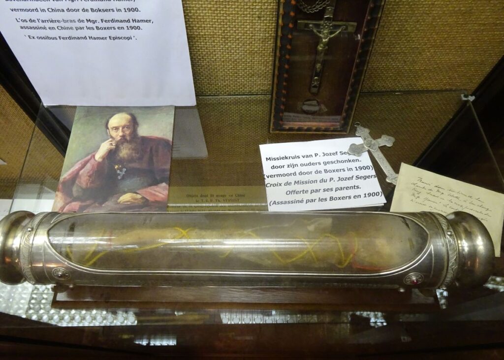 Het bot van een bovenarm van Hamer als relikwie in een vitrine in de kapelcrypte.