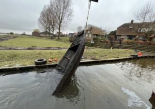 De boerenschouw wordt boven water gehaald in het havenkanaal de Keen in Strijen