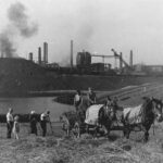 Boeren hooien in de schaduw van de staalfabriek van Völklingen omstreeks 1947. Het Saarland, een Frans-Duitse grensregio en oud industriegebied, was sinds het in de jaren 1850 werd geïndustrialiseerd lang een bastion van mijnbouw en metallurgie.