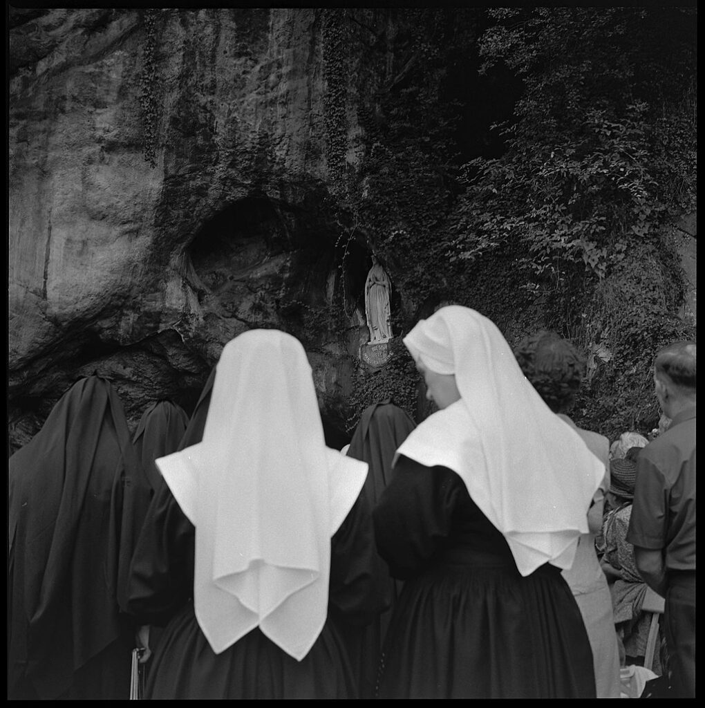 Bedevaartgangers bij de grot in Lourdes