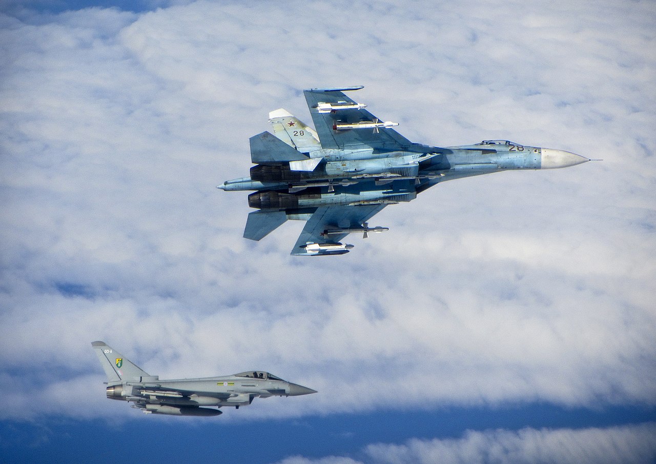 Een Royal Air Force Eurofighter Typhoon (onder) begeleidt de Russische luchtmacht Su-27 Flanker (boven) boven de Oostzee in juni 2014
