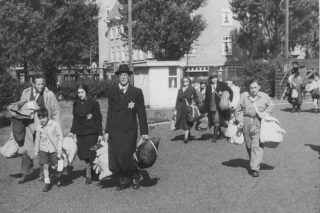 Joodse gezinnen onderweg naar de verzamelplaats op het Olympiaplein tijdens de laatste grote razzia in Amsterdam op 20 juni 1943