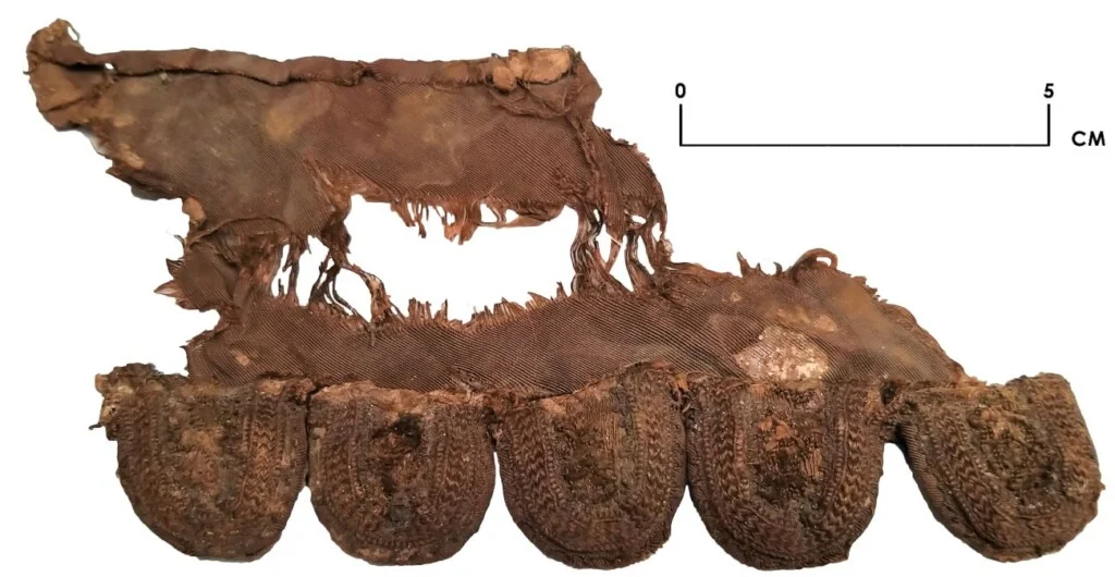 Kledingfragment met een sierlijke geschulpte rand