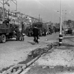 Duitse militairen staan na hun overgave op het punt te vertrekken, met vrachtauto's vol gevorderde spullen, waaronder fietsen.