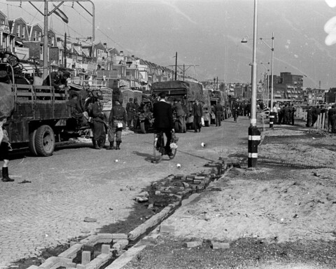 Duitse militairen staan na hun overgave op het punt te vertrekken, met vrachtauto's vol gevorderde spullen, waaronder fietsen.