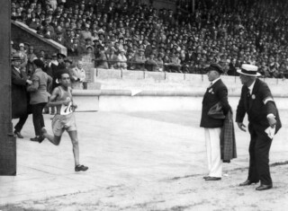 El Ouafi rent als allereerste via de Marathonpoort het Olympisch Stadion in