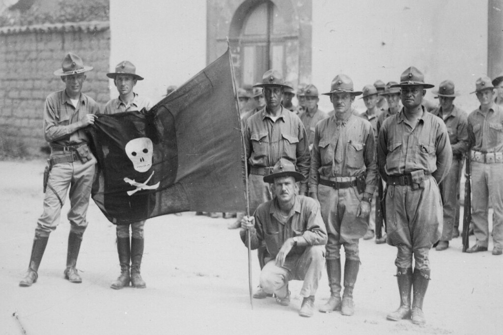 Mariniers uit de VS met buitgemaakte rood-zwarte vlag van Sandino
