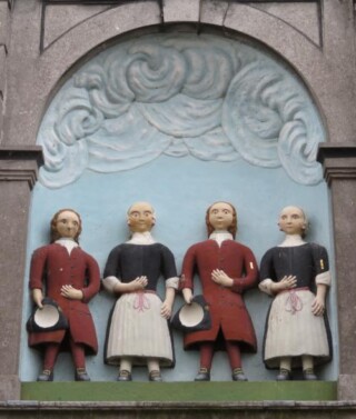 De Vier Weeskinderen boven de poort van het gelijknamige gereformeerde weeshuis uit 1765 aan de Torenstraat in Medemblik.