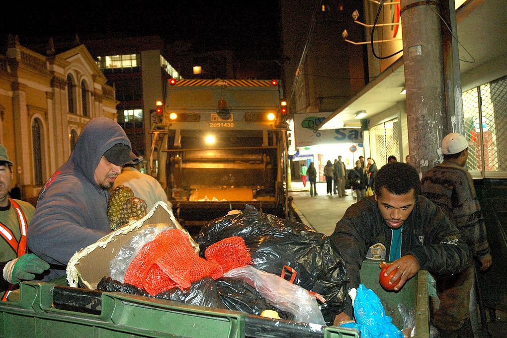 Dumpster divers halen etenswaren uit een container