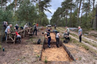 Studenten en vrijwilligers zeven grond uit een proefsleuf over de wal en gracht van het Romeinse kamp bij Leuvenum, op zoek naar archeologische vondsten.