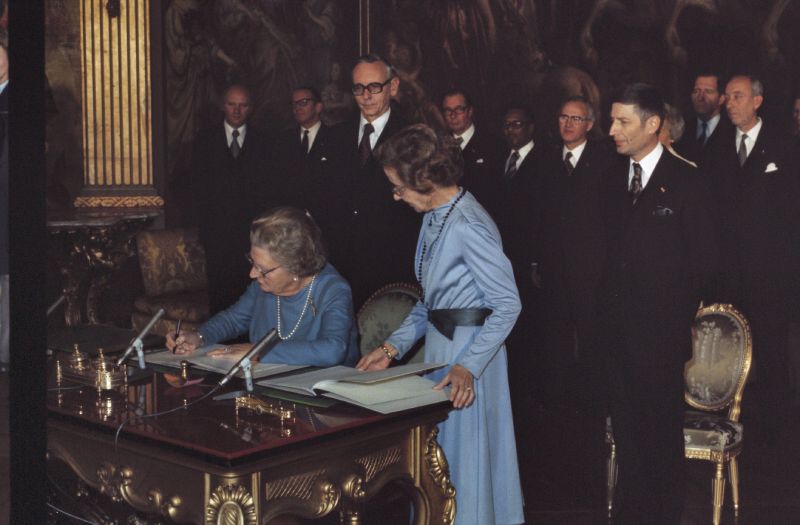 Koningin Juliana ondertekent de overeenkomst ter erkenning van de Republiek Suriname, in aanwezigheid van Minister van Justitie Dries van Agt.