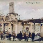 Duitse soldaten en burgers voor de ruïne van een uitgebrande fabriek in het Oost-Pruisische Gumbinnen