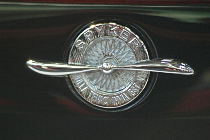 Logo Spyker: spaakwiel met een propeller